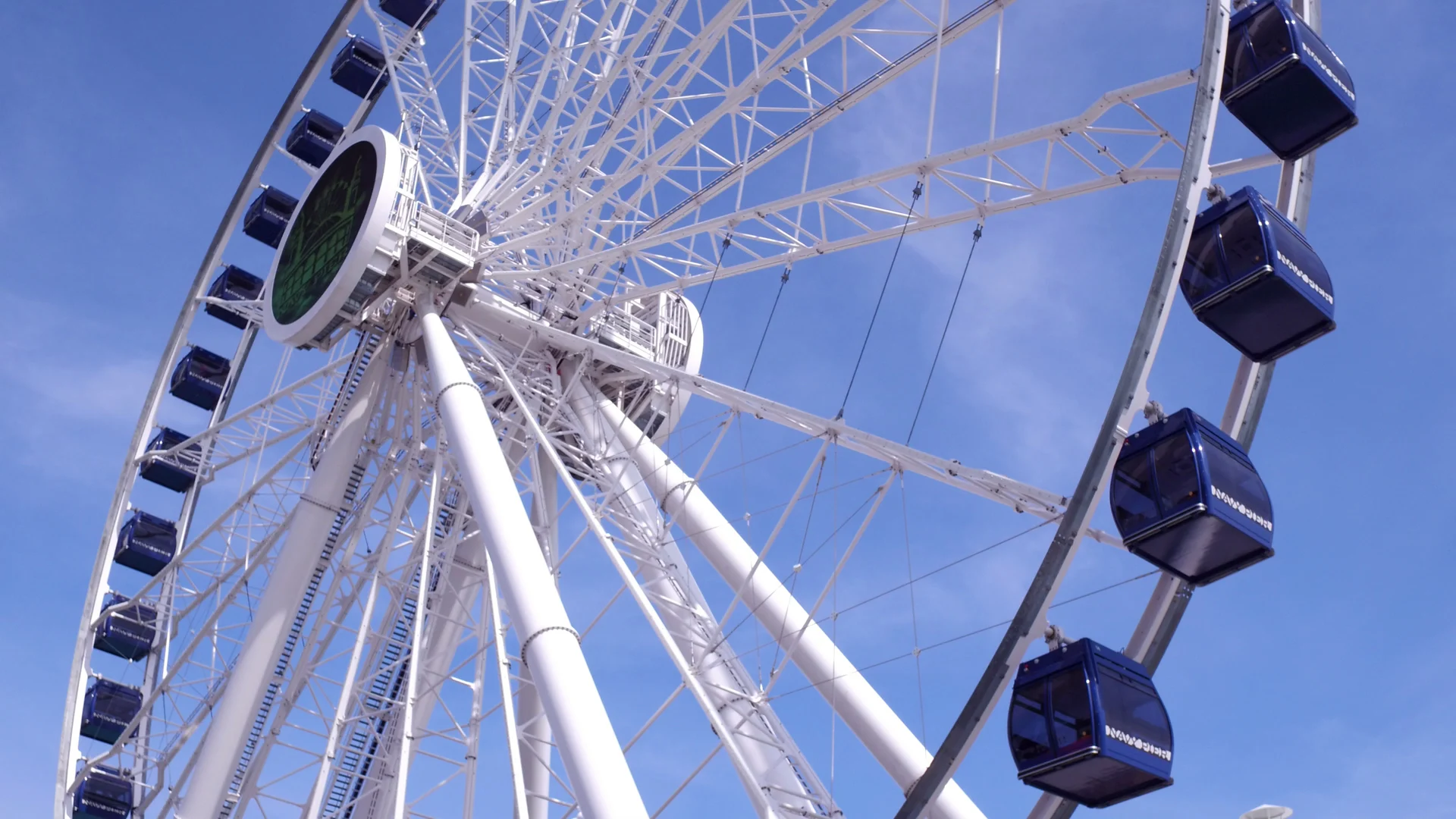 Blaue Gondeln und weißes Gerüst des Centennial Wheel vor klarem Himmel