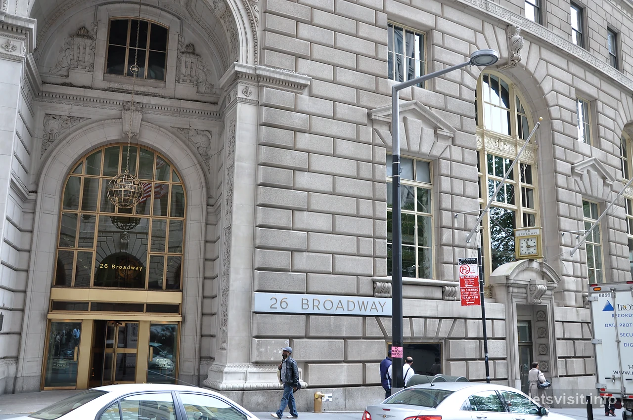 Pintu masuk batu melengkung dan papan 26 Broadway di Lower Manhattan