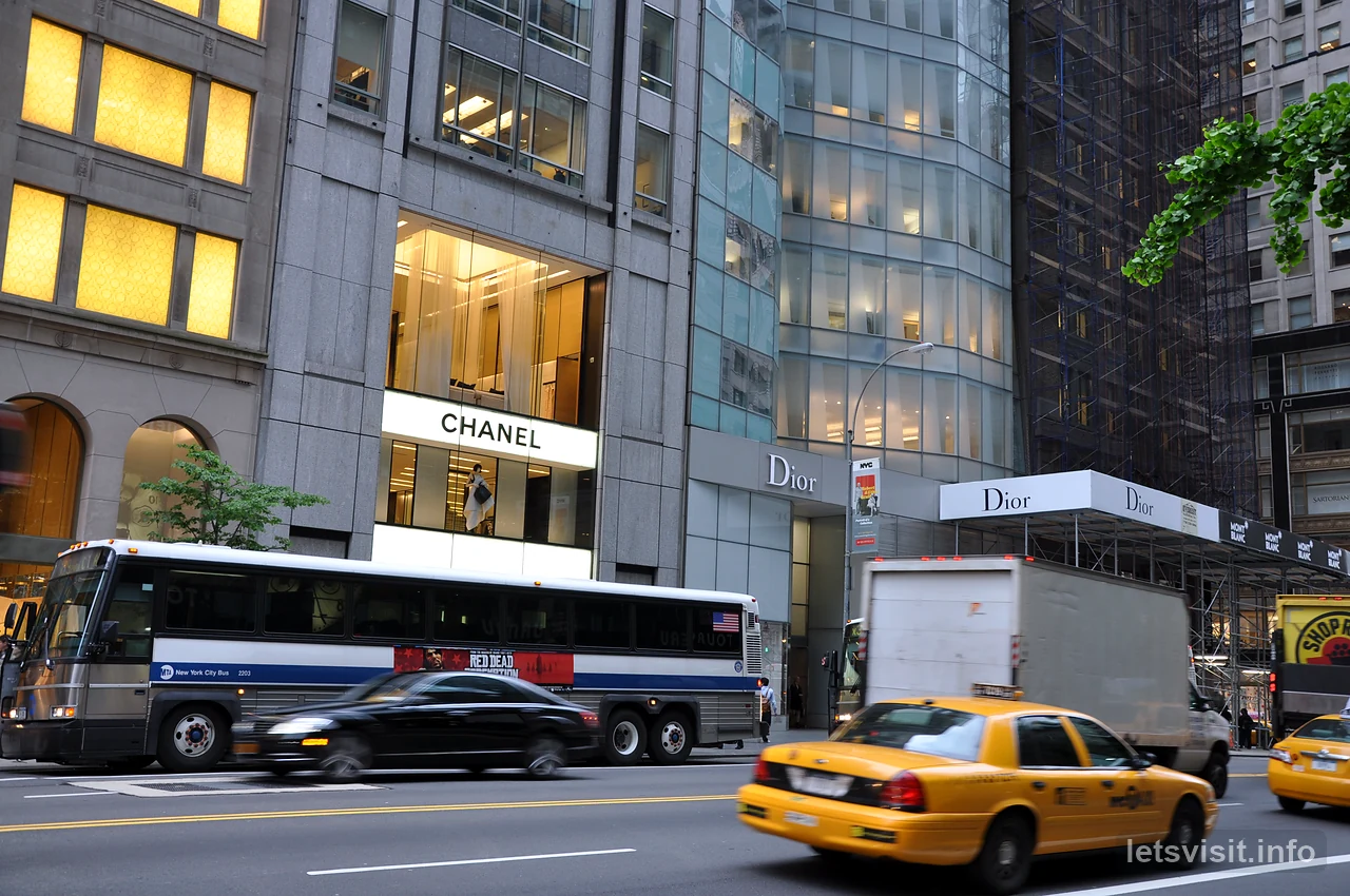 Teksi kuning dan bas bandar di sisi deretan kedai Fifth Avenue