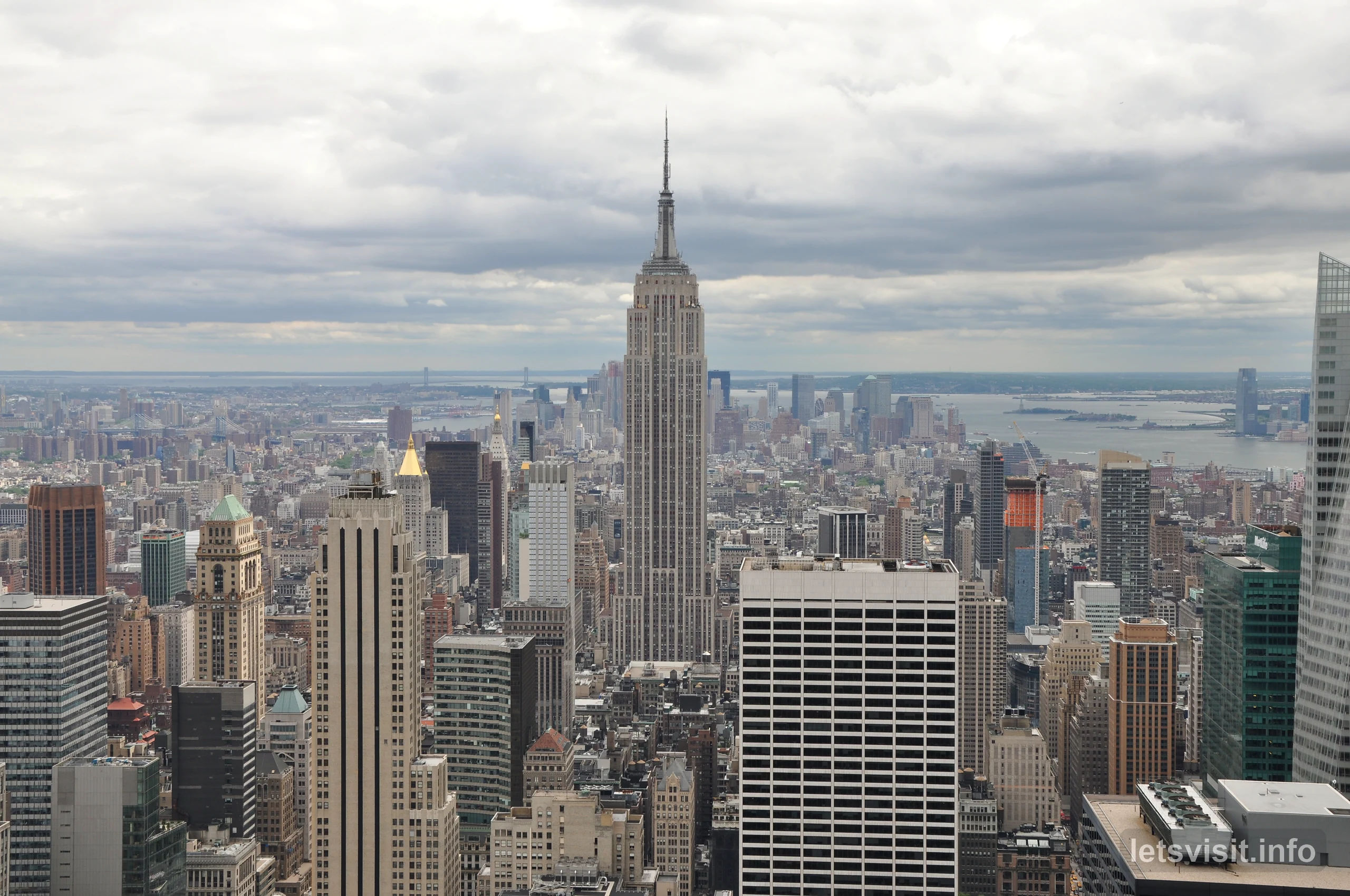 Empire State Building över Manhattans silhuett under molnen