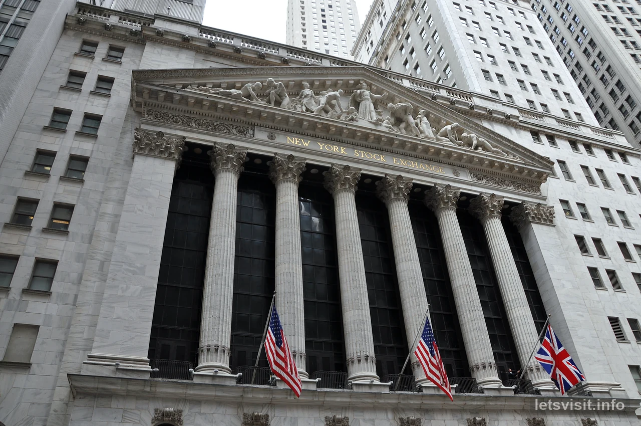 Fasad Bursa Saham New York bertiang dengan bendera Amerika