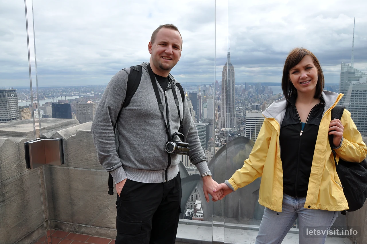 Dua pengembara di dek pemerhatian dengan Empire State Building di belakang