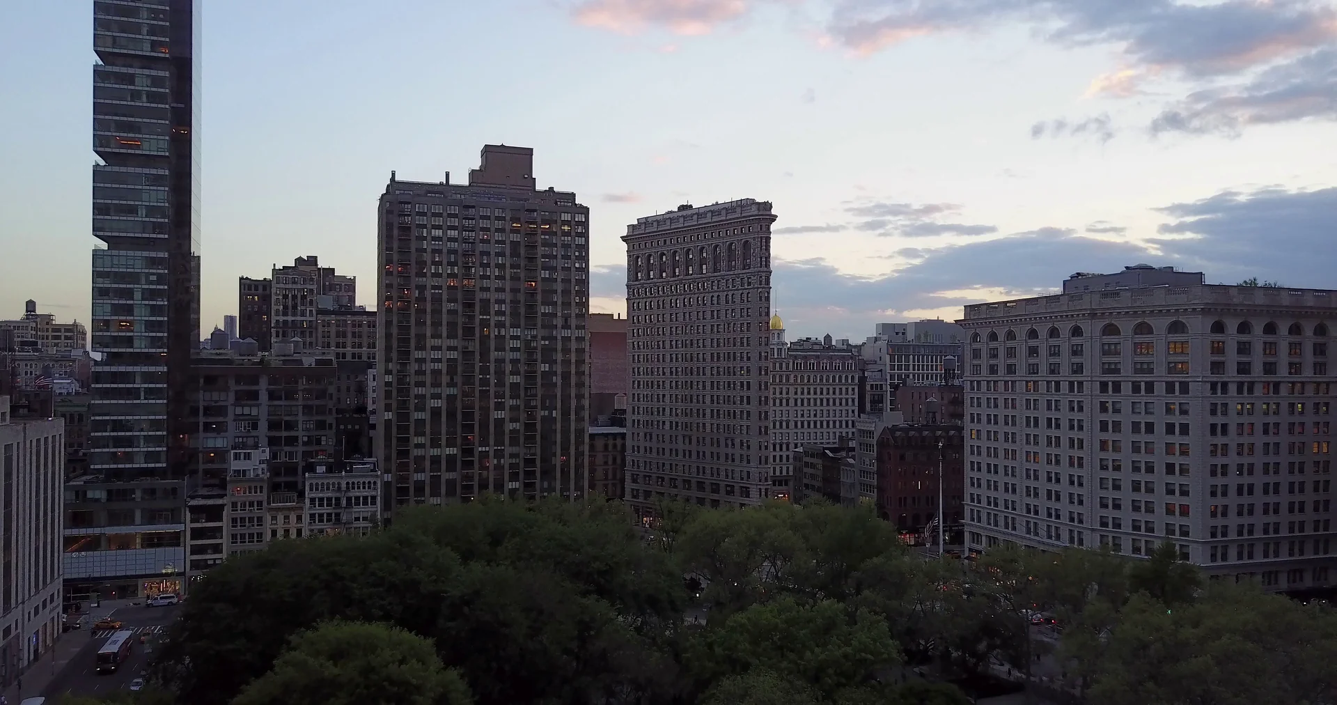 Edifício Flatiron acima das árvores do Madison Square Park ao anoitecer