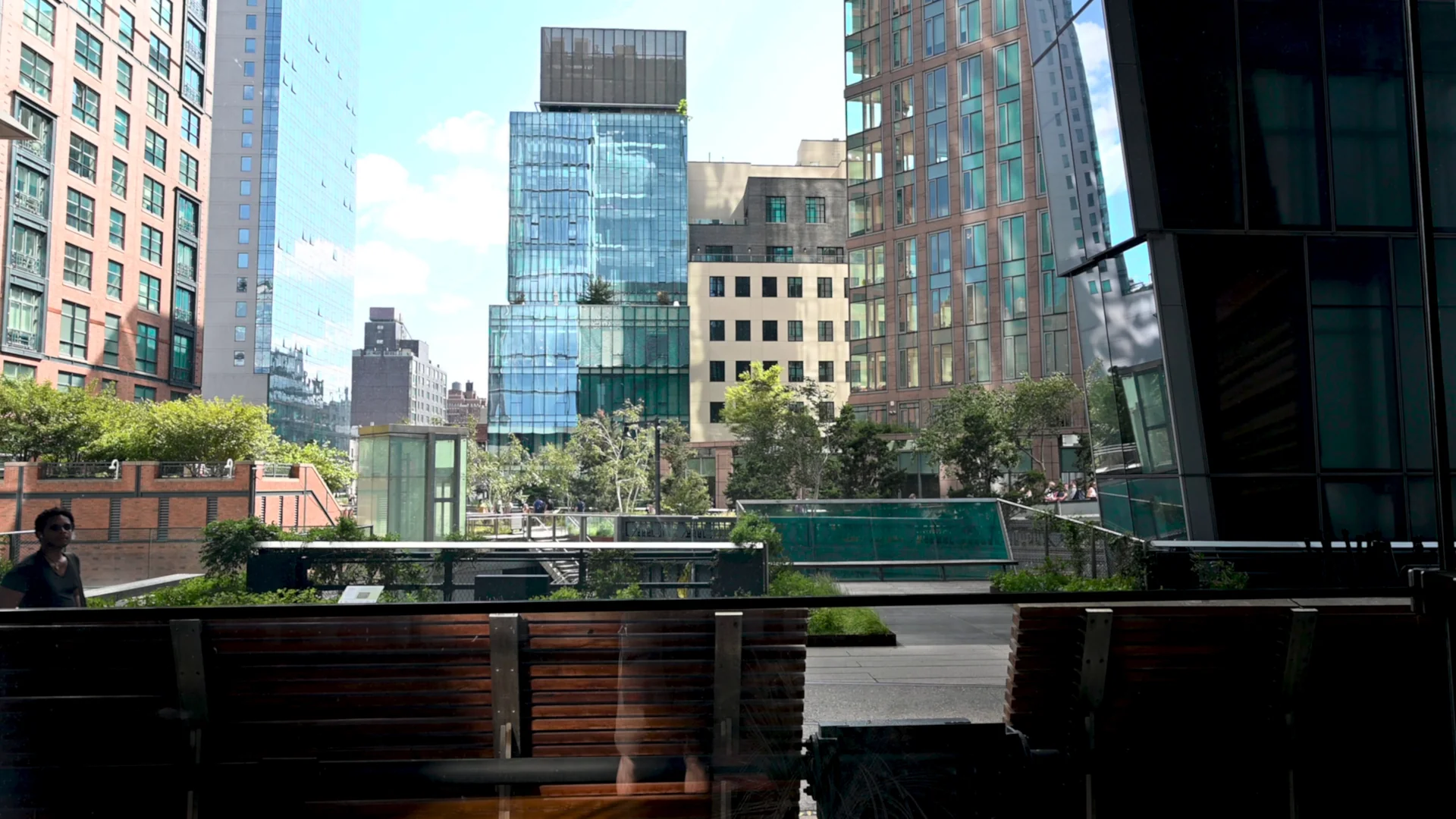 Assentos e vegetação no High Line entre edifícios do West Side