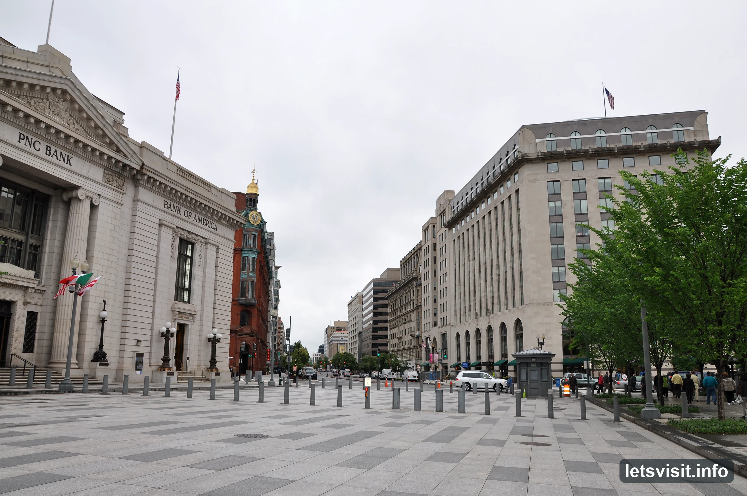 Broad Washington street lined with stone buildings beneath an overcast sky